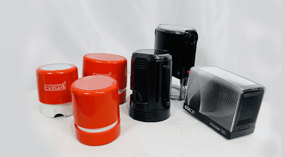 Collection of various red and black self-inking stamps on a white background.